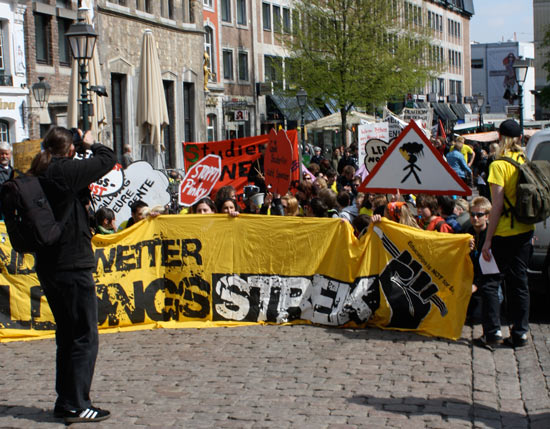 Auf dem Marktplatz setzt sich der gesamte Protestzug kurz hin. Ein andere Fotograf steht im Vordergrund.